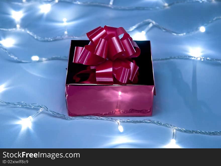 Red gift box with bow on white garland