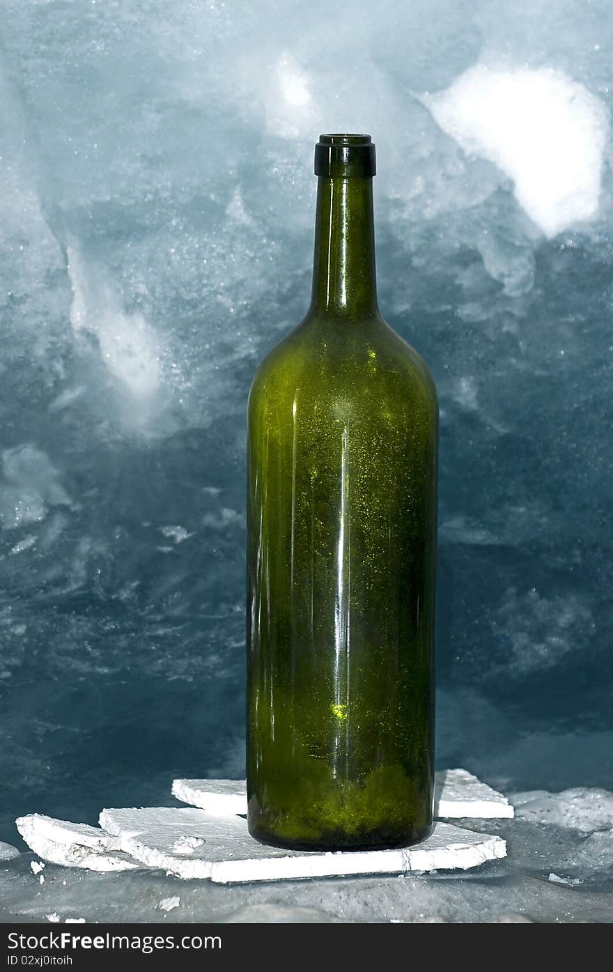 Empty green bottle on ice