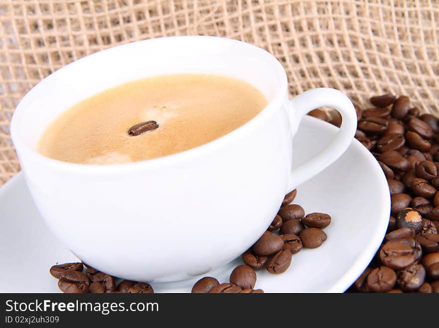 Cup of coffee decorated with a bean and coffee beans