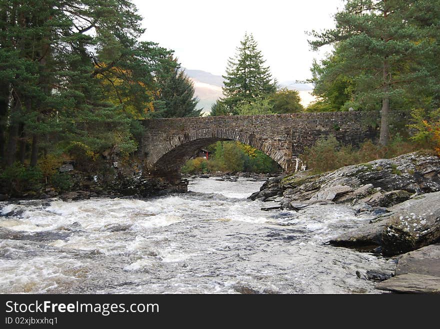 A view of the river dochart as it approaches an old stone bridge. A view of the river dochart as it approaches an old stone bridge