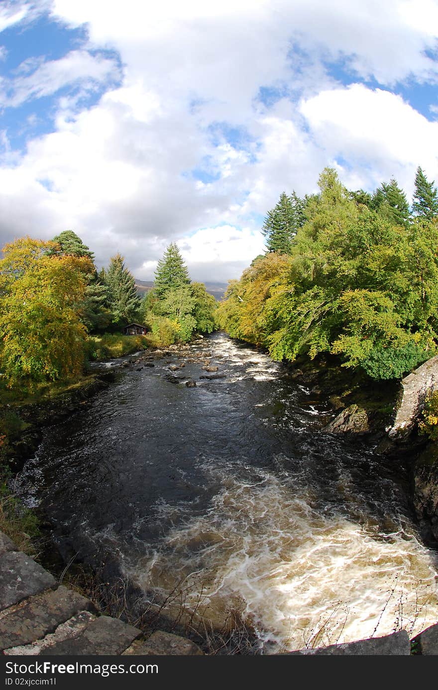 A view from the old stone bridge of the river dochart as it flows away from the falls. A view from the old stone bridge of the river dochart as it flows away from the falls