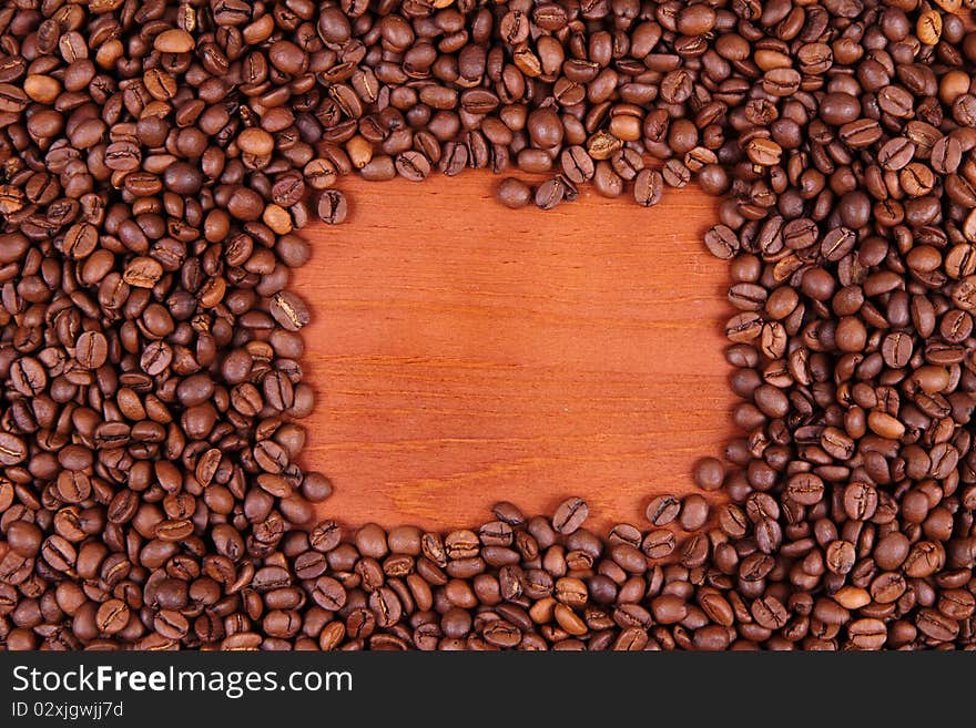 Coffee beans with wooden background in the middle with space for text