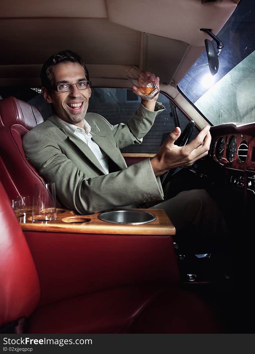 Happy man in the car drinking