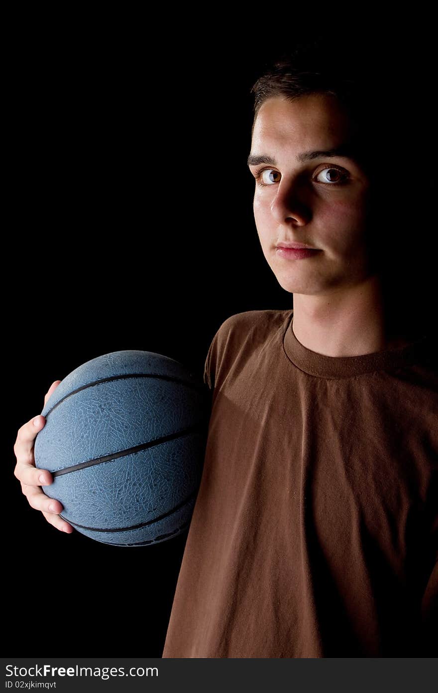 Young teenage basketball player in a studio setting with hip athletic clothing. Young teenage basketball player in a studio setting with hip athletic clothing.