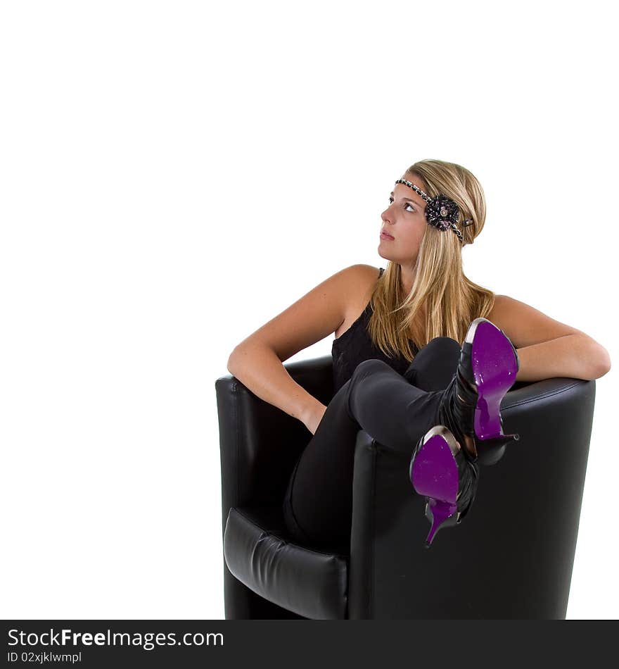 Young stylish teenager sitting in a balck chair with purple shoes. Young stylish teenager sitting in a balck chair with purple shoes.