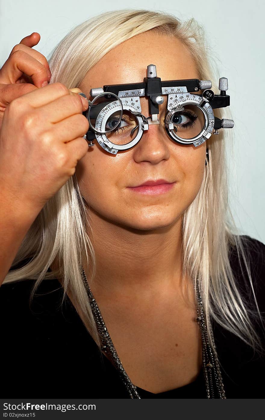 Young woman examining the eyesight in the optician's