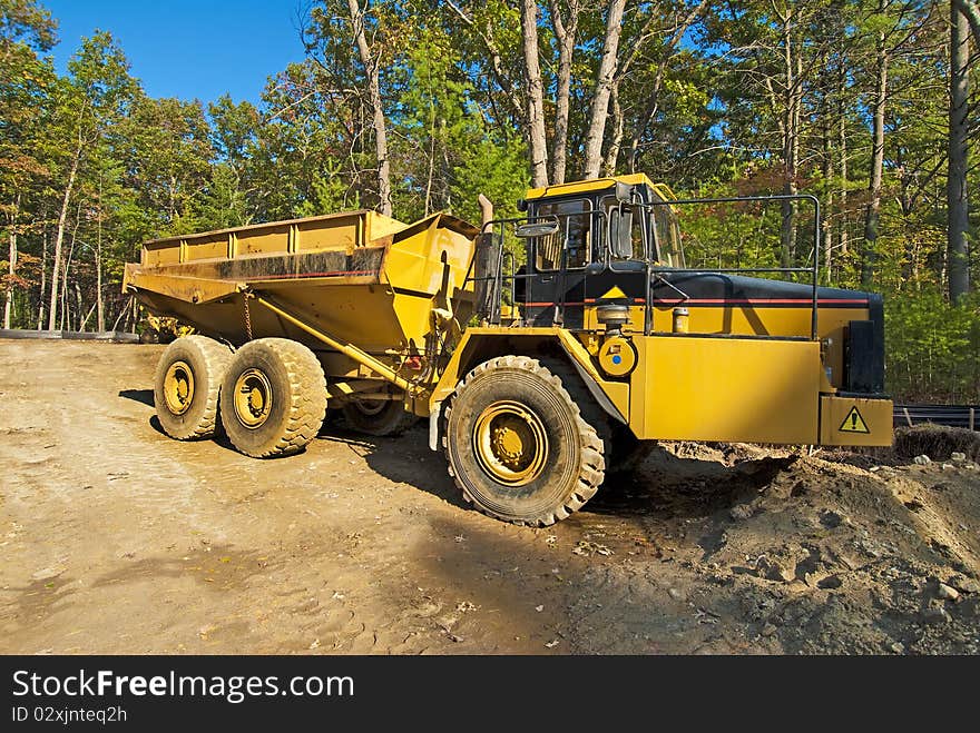 Big, yellow earth moving truck on a job construction site