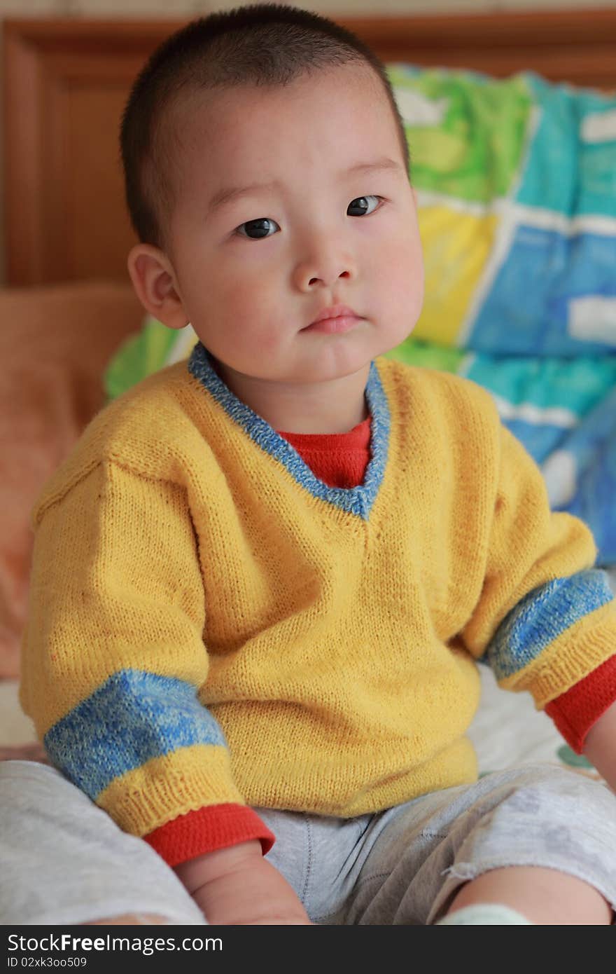 Lovely chinese baby sitting on the bed. Lovely chinese baby sitting on the bed