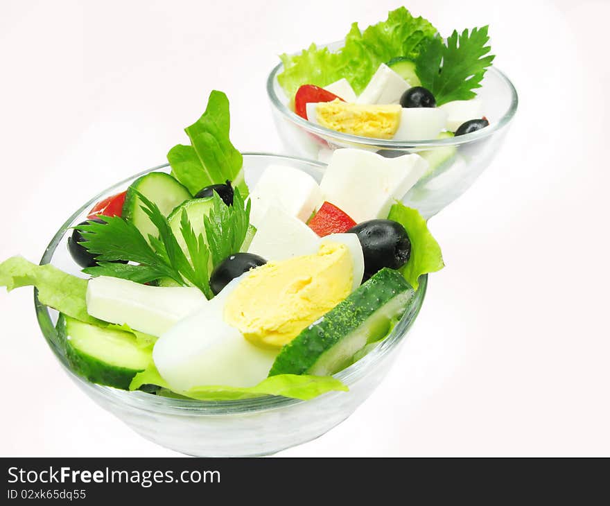 Greek salad with cheese egg olive and tomato in two glass bowls. Greek salad with cheese egg olive and tomato in two glass bowls