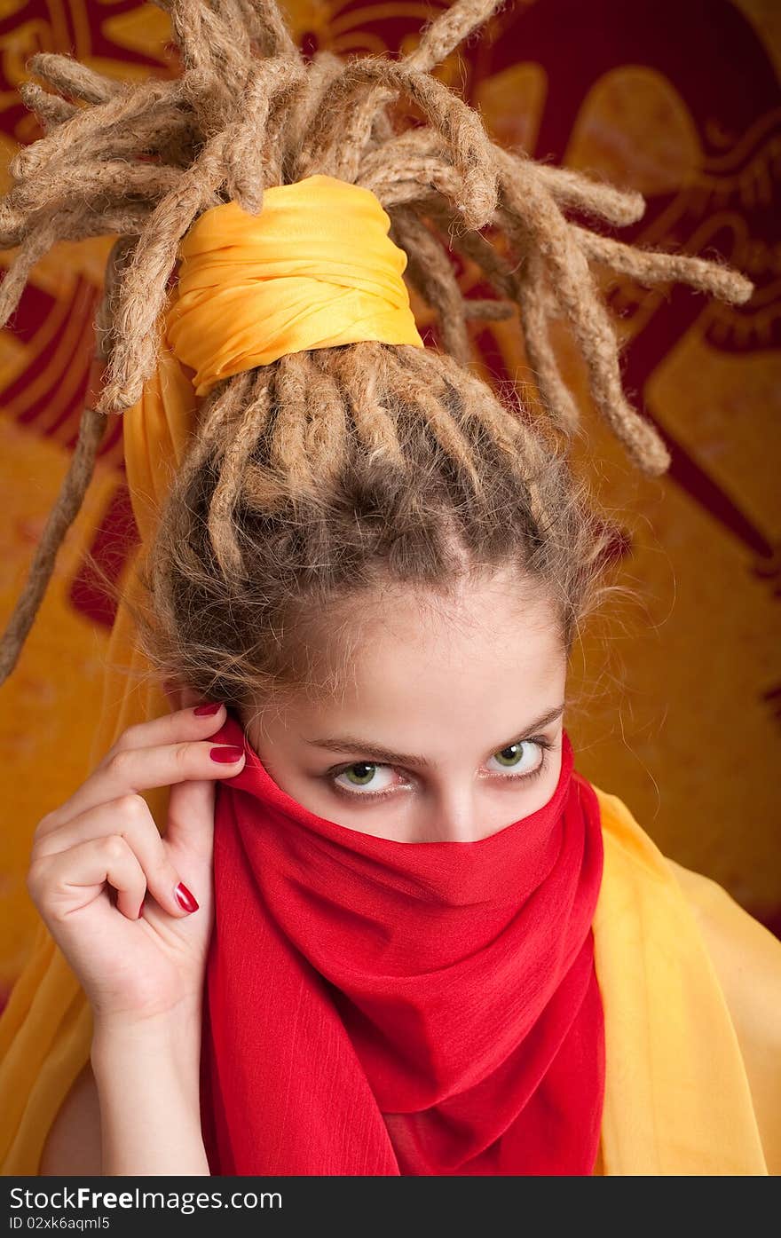 Young woman with African dreadlocks in yellow and red cloth covered the face. Young woman with African dreadlocks in yellow and red cloth covered the face