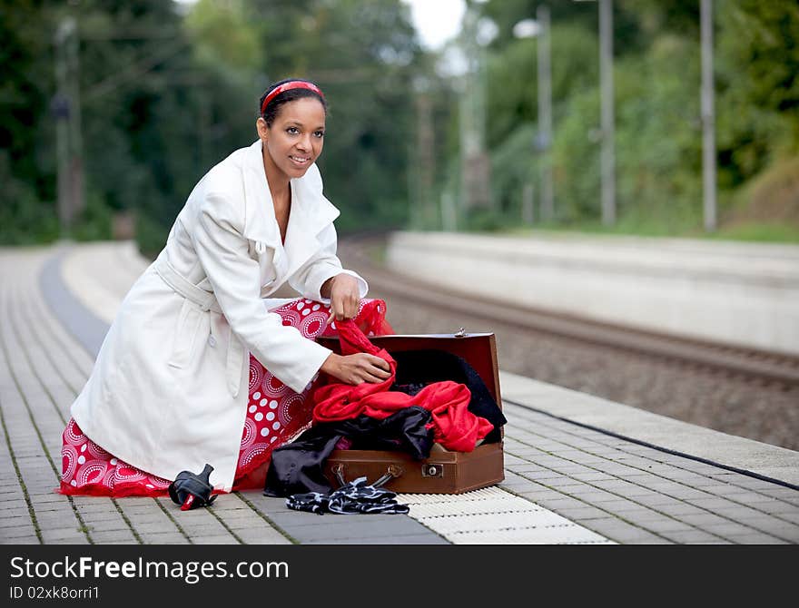 A young woman rummages in her suitcase. A young woman rummages in her suitcase