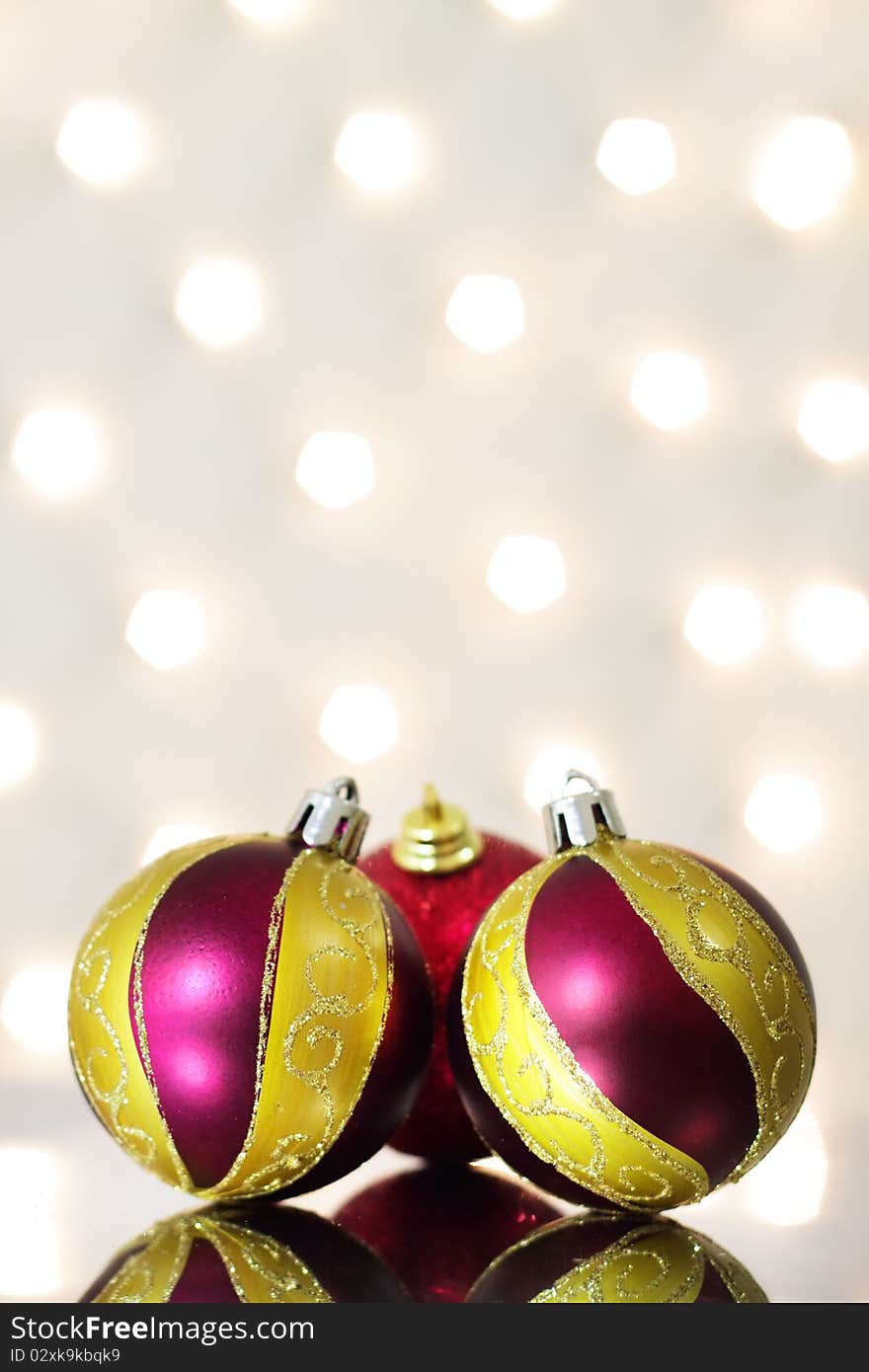 Three red Christmas ball on a background of lights