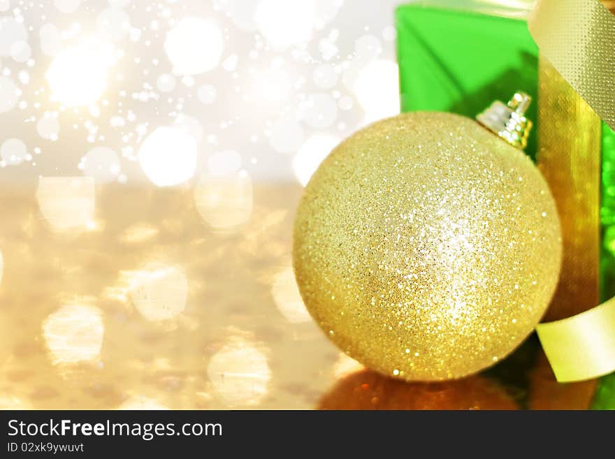 Gift box and Christmas ball on a background of lights