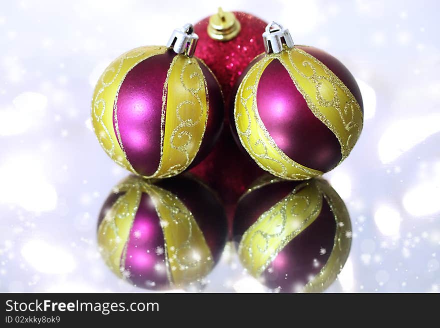 Three red Christmas balls on a background of lights