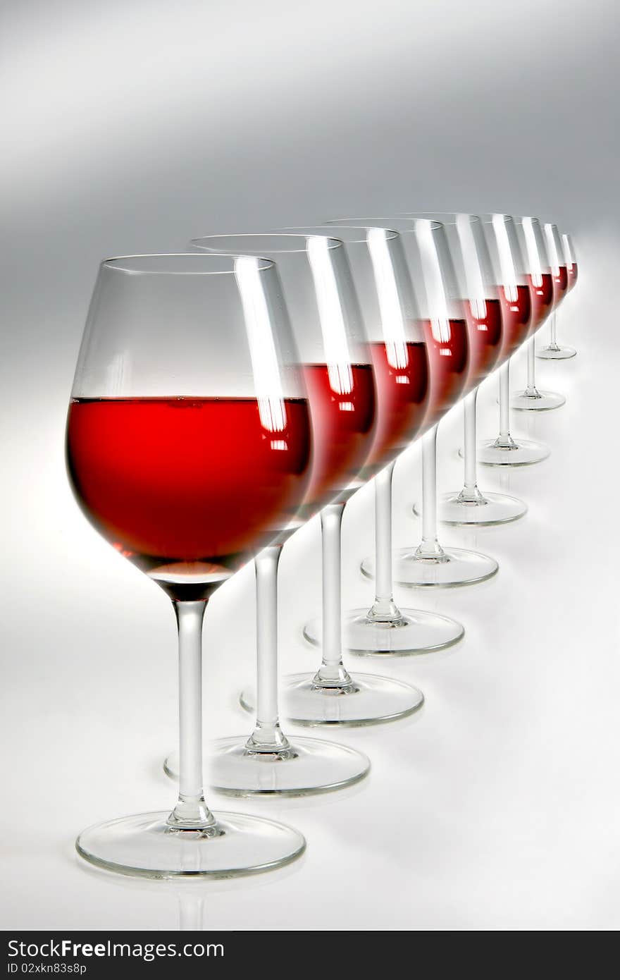 Raw of glasses with red wine on neutral background