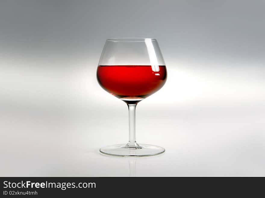 Glass with red wine on neutral background