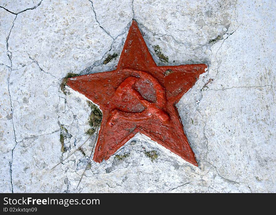 Red soviet star on cracked wall of a monument