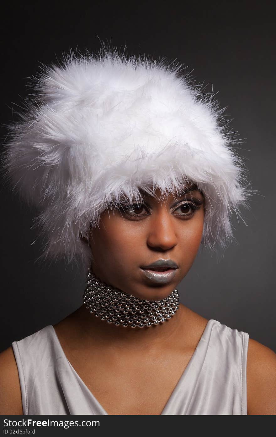 Glamour african woman in white hat and silver necklace