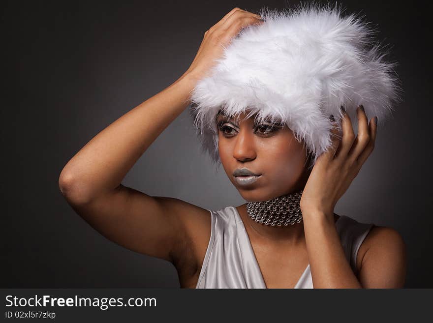 African woman in white hat and silver necklace