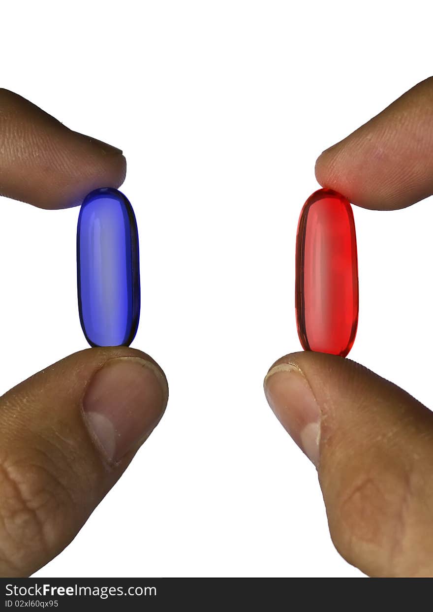 Closeup of fingers holding  blue and red pills against white background. Closeup of fingers holding  blue and red pills against white background