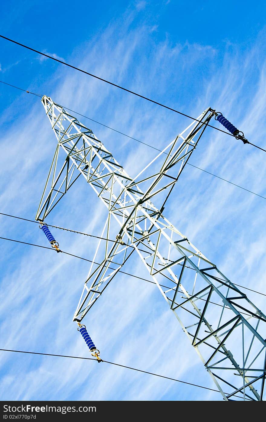 Pylon and transmission power line on blue sky background