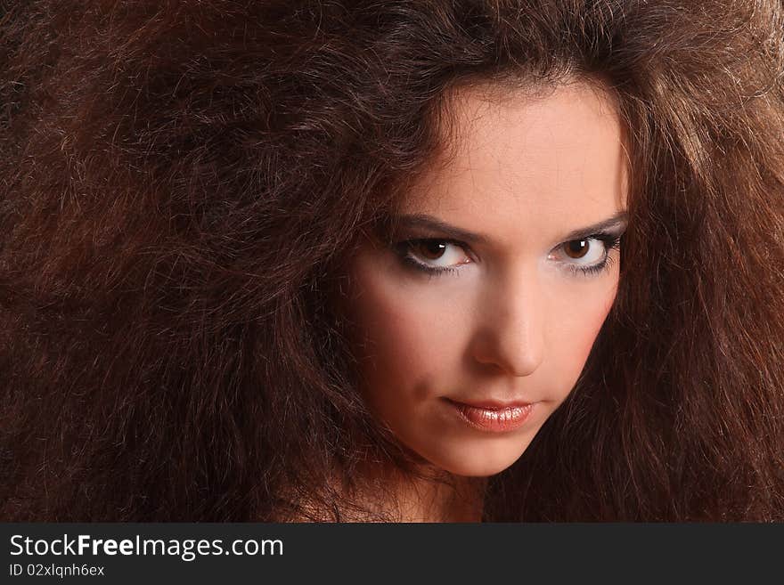 Portrait of the beautiful young woman with a magnificent hairdress on a black background.