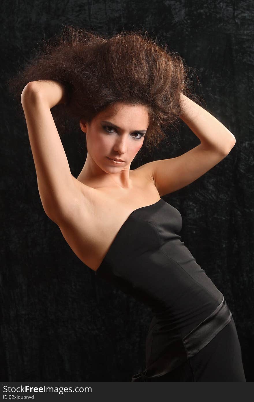 Portrait of the beautiful young woman with a magnificent hairdress on a black background.