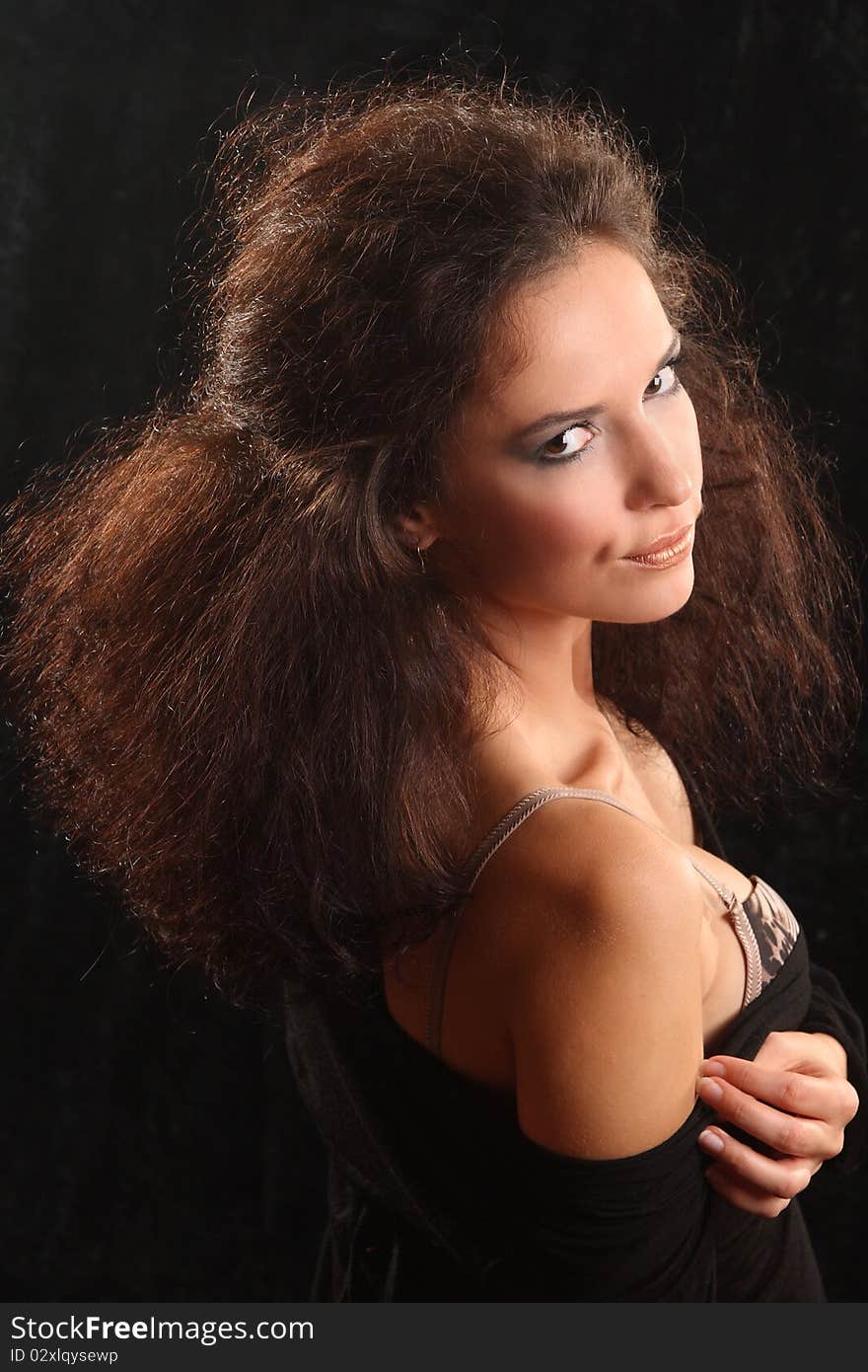 Portrait of the beautiful young woman with a magnificent hairdress on a black background.