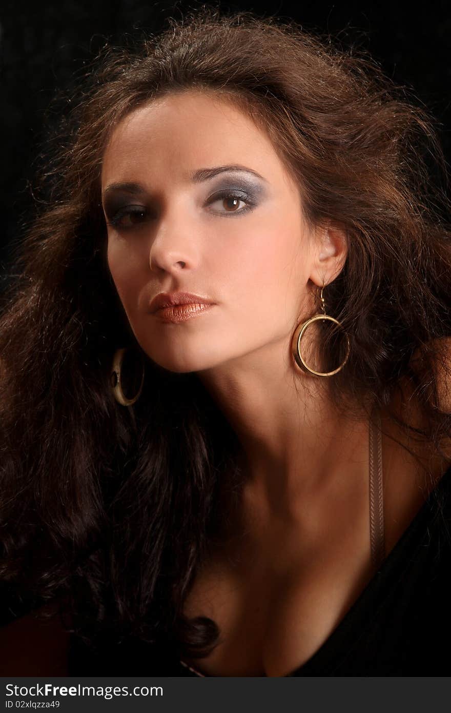 Portrait of the beautiful young woman with a magnificent hairdress on a black background.