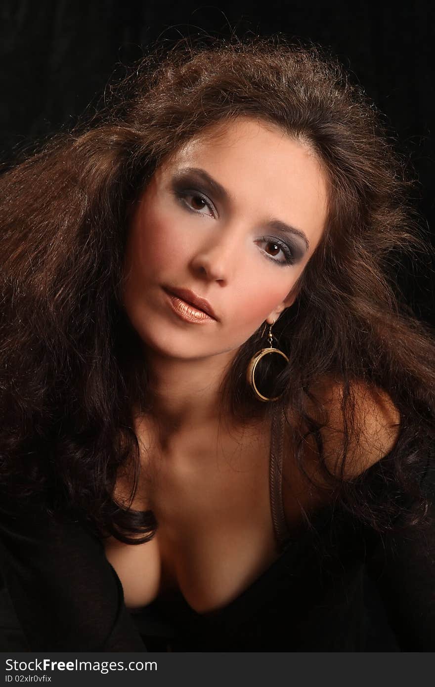 Portrait of the beautiful young woman with a magnificent hairdress on a black background.