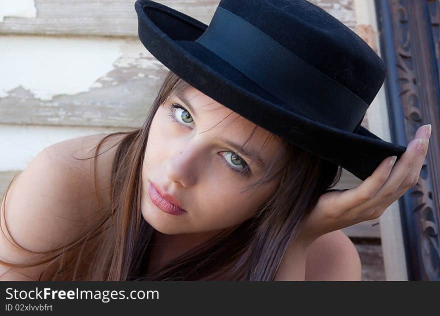 A portrait of a pretty teenager wearing a black hat and staring at the viewer. A portrait of a pretty teenager wearing a black hat and staring at the viewer