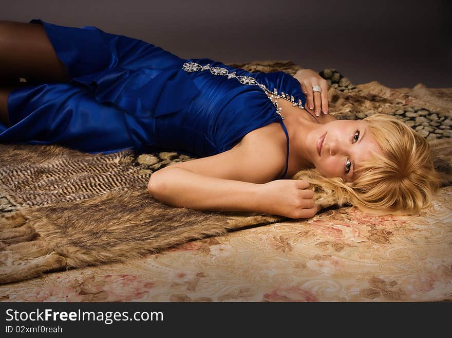 Aristocratic lady in a dark blue dress lying on the floor