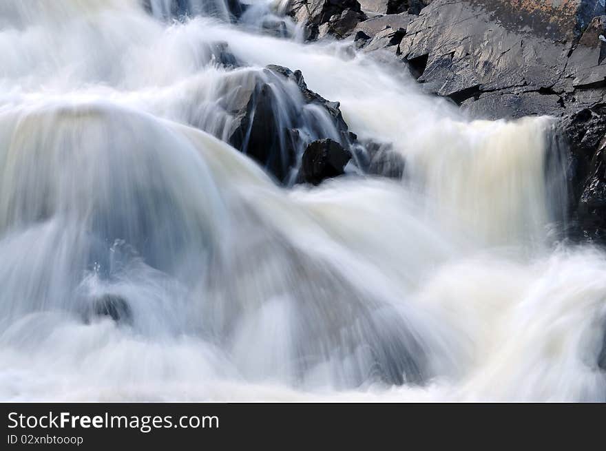 Details of cascading rocky waterfall with slow motion blur. Details of cascading rocky waterfall with slow motion blur.