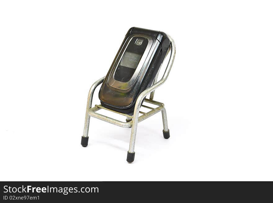 Old Mobile Phone on small chair  and white backgroud