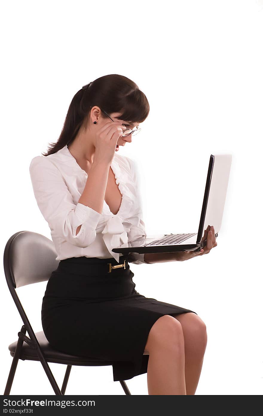 Beautiful business woman with dark hair wearing glasses is sitting with a laptop. Beautiful business woman with dark hair wearing glasses is sitting with a laptop