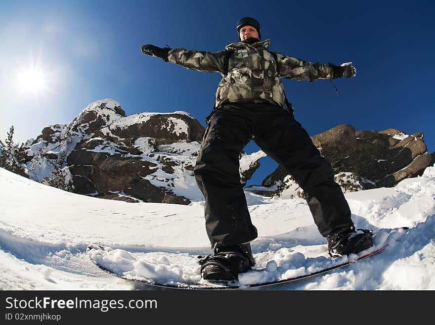 Snowboarder doing a toe side carve with deep blue sky in background