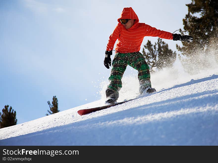 Snowboarder doing a toe side carve with deep blue sky in background