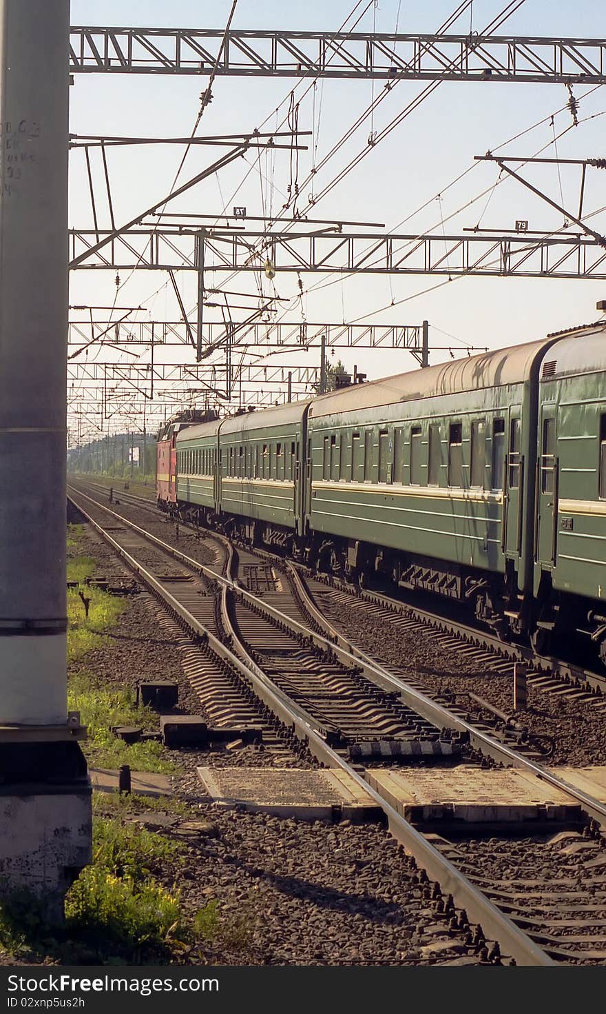 Locomotive with a green wagon rides on railway tr