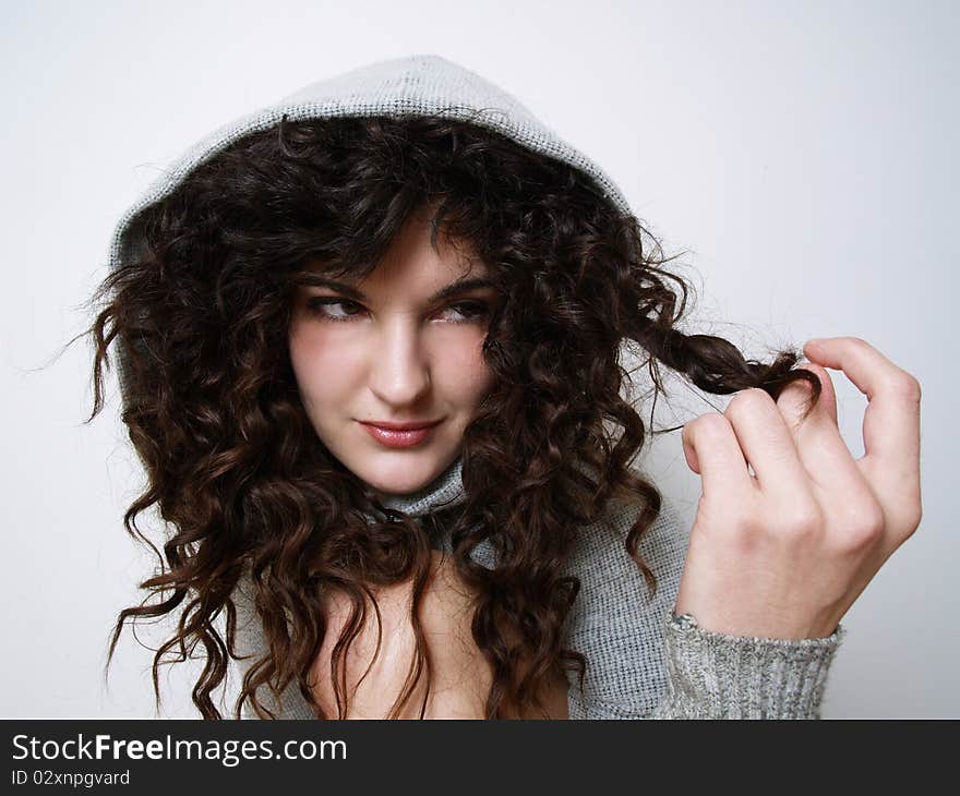 Young girl in hood playing with her hair