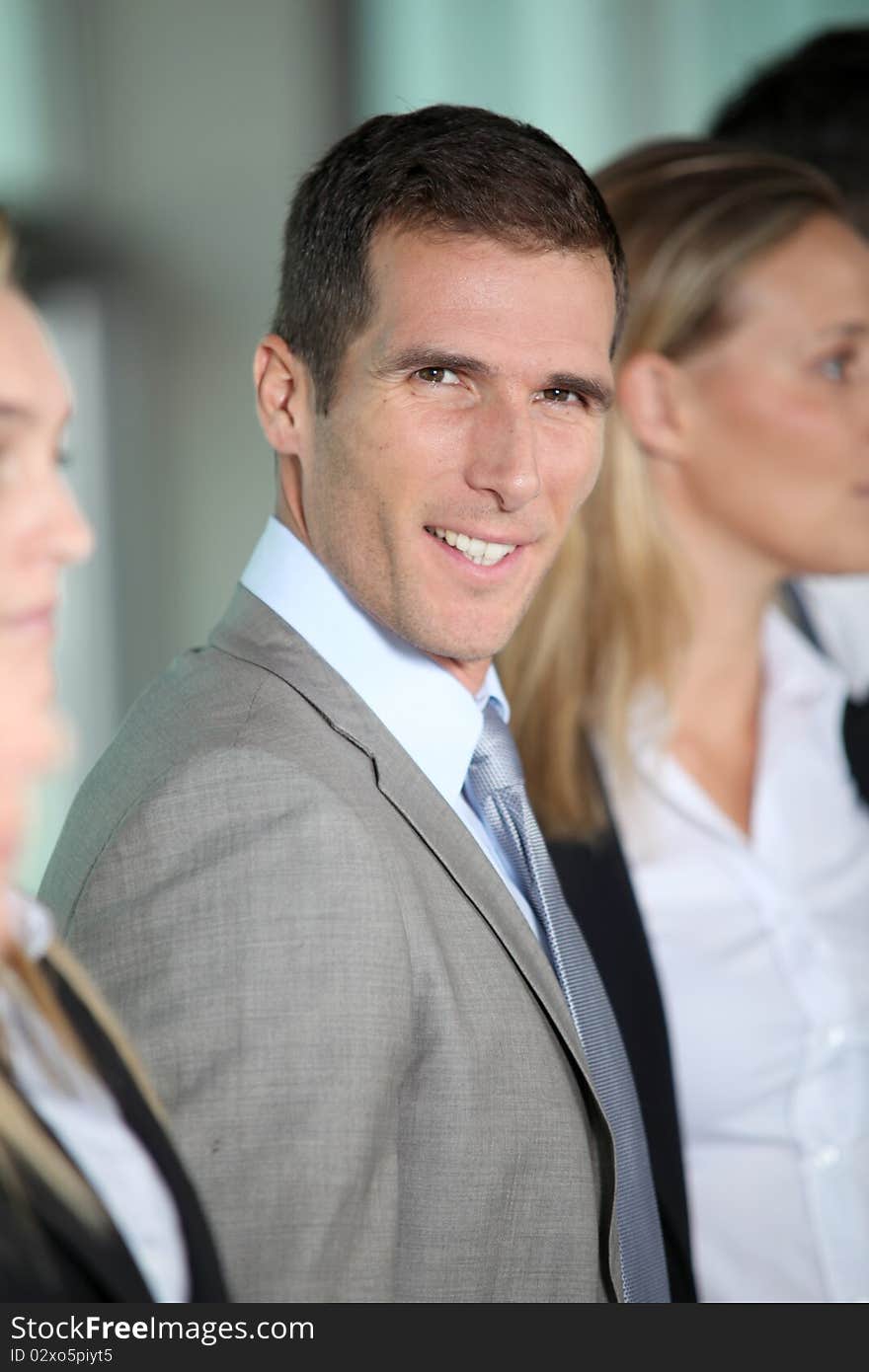 Smiling businessman in front of group. Smiling businessman in front of group