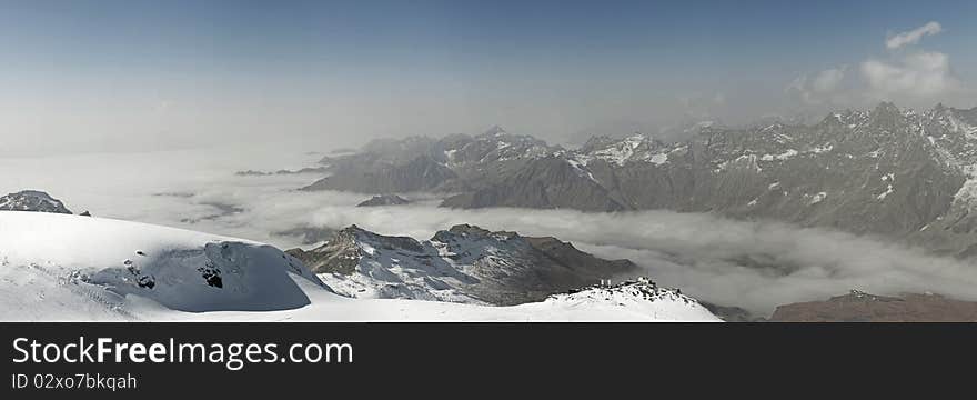 Panorama image of the misty Alpine mountains. Panorama image of the misty Alpine mountains