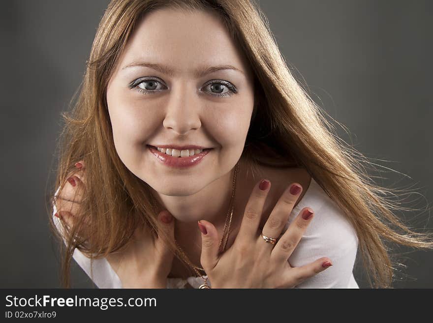 Beautiful woman smiles on a grey background