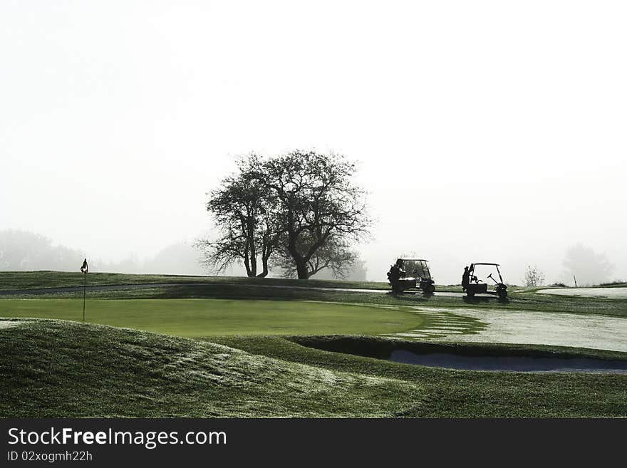 Golf carts waiting on green