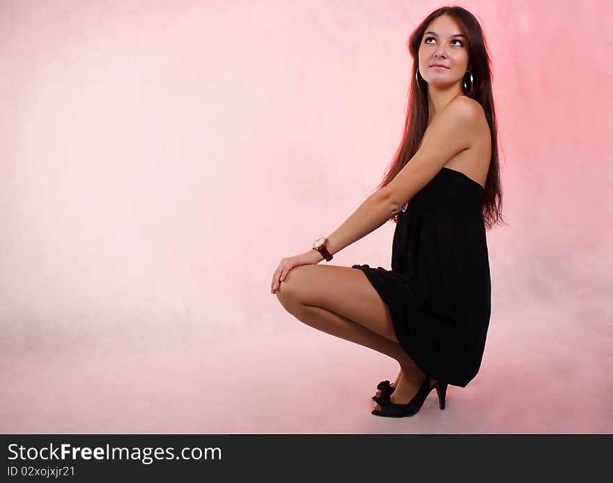 The beautiful russian girl sits on the white-red background. The beautiful russian girl sits on the white-red background.