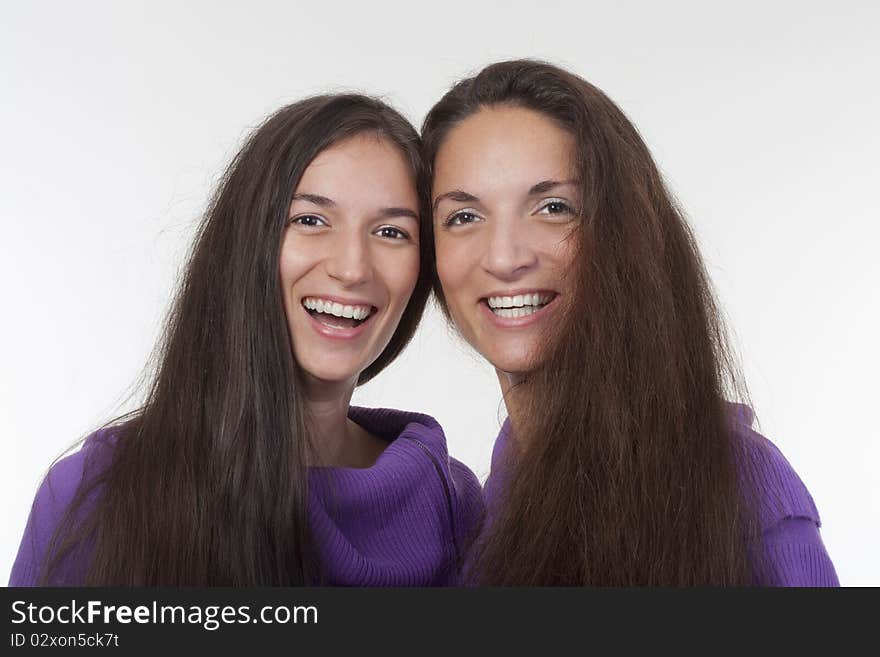 Two sisters with very long brown hair standing smiling. Two sisters with very long brown hair standing smiling