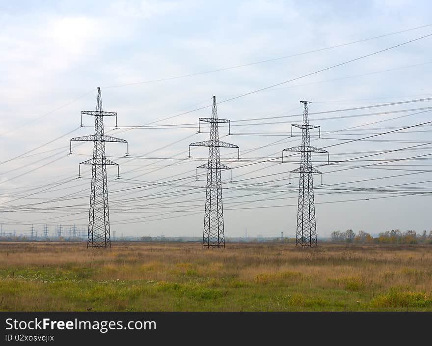 Steel power transmission towers in the background of the autumn sky. Steel power transmission towers in the background of the autumn sky