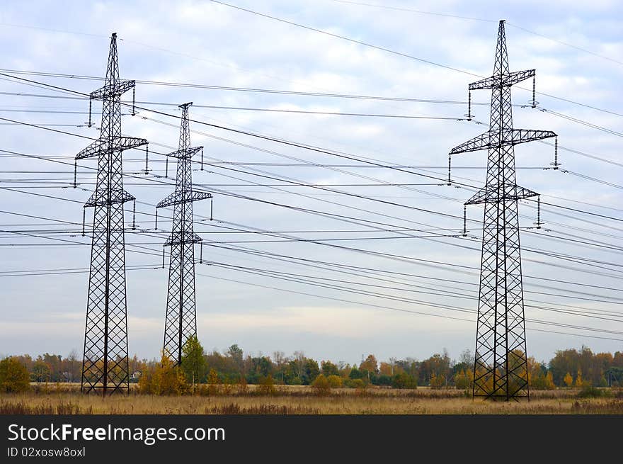 Steel power transmission towers in the background of the autumn sky. Steel power transmission towers in the background of the autumn sky