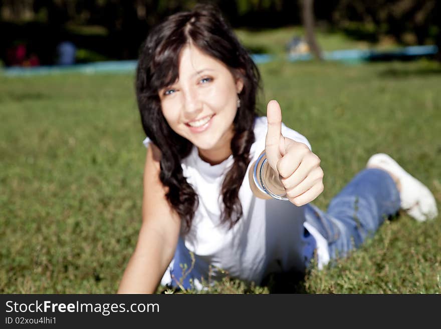 Girl with blue eyes on green grass in the park.