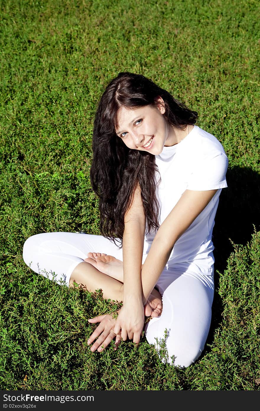 Brunet Yoga Girl On Green Grass In Park.