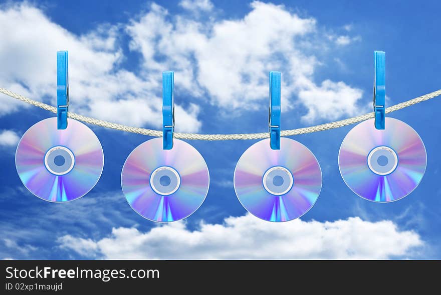 Cd on rope with clothes pin over blue sky background